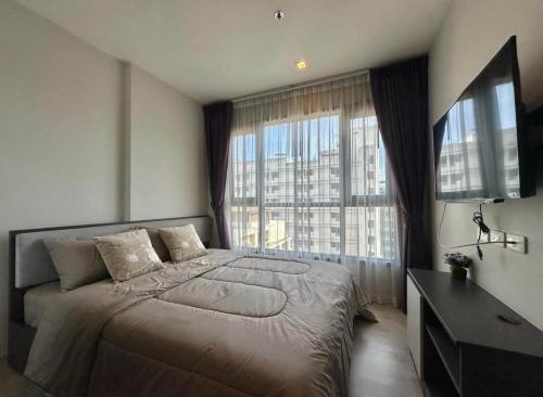 Pattaya the base condo في باتايا سنترال: غرفة نوم بسرير كبير ونافذة كبيرة