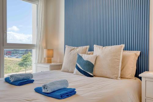 a bedroom with a bed with pillows and a window at Suite Olonna Spa et Terrasse à 7 min des plages in Les Sables-dʼOlonne