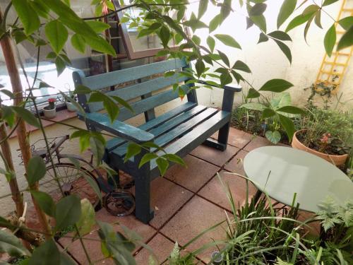 un banco azul en un jardín con plantas en Bobbie B's Kosher BnB, en Johannesburgo