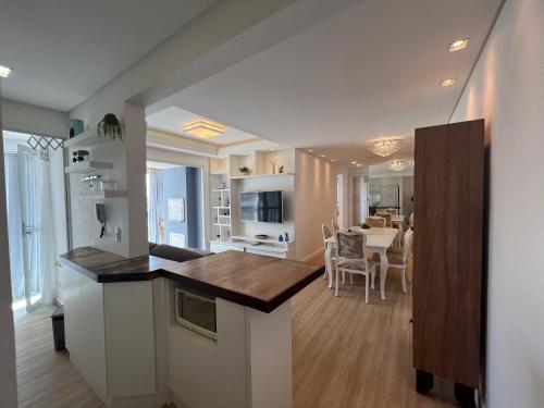 a kitchen and living room with a table and a dining room at Nautilus Apto Beiramar Churrasqueira Piscina Beto Carrero in Penha