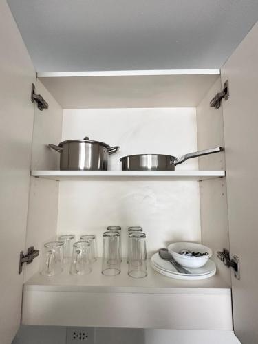 a kitchen with glass jars and a bowl on a shelf at Covent Garden Condominium in Manila