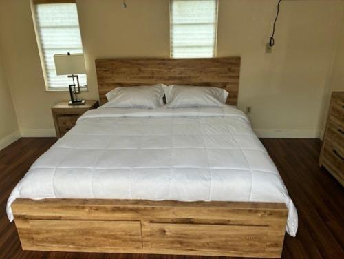 a bedroom with a large bed with a wooden headboard at Miami Spacious Executive Suite in Miami