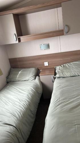 two beds sitting next to each other in a room at Heysham Coastal Escape Family 3-Bed Caravan in Heysham