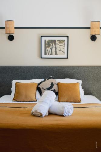 a bed with a pair of towels on it at Les Villas du Château de Lastours in Portel-des-Corbières