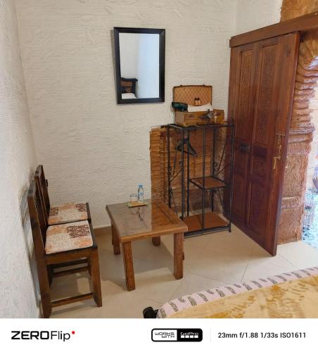 a room with a table and a chair and a mirror at Dar Si hmed in Rabat