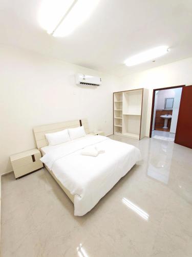 a white bedroom with a large white bed in it at Nizwa Diamond ماسة نزوى in Nizwa