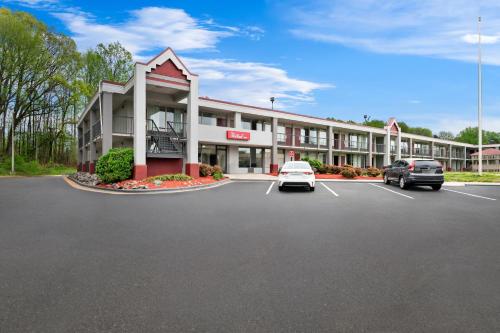 a hotel with cars parked in a parking lot at Red Roof Inn Charlotte - Airport in Charlotte