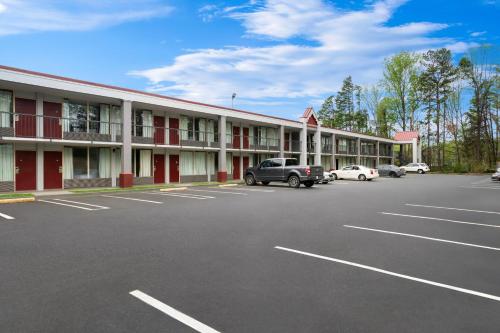 a hotel with cars parked in a parking lot at Red Roof Inn Charlotte - Airport in Charlotte