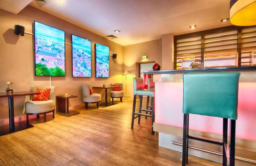 a bar with chairs and a counter in a room at Leonardo Hotel Heidelberg Walldorf in Walldorf