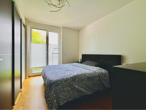 a bedroom with a bed and a window at Modern 3-Room Apartment in Stuttgart City Area in Stuttgart