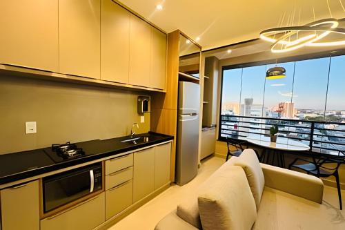 a kitchen with a couch and a table with a view at Loft Skyline - Vista de tirar o fôlego para cidade! in Uberlândia
