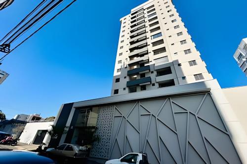 a tall white building in front of a building at Loft Skyline - Vista de tirar o fôlego para cidade! in Uberlândia