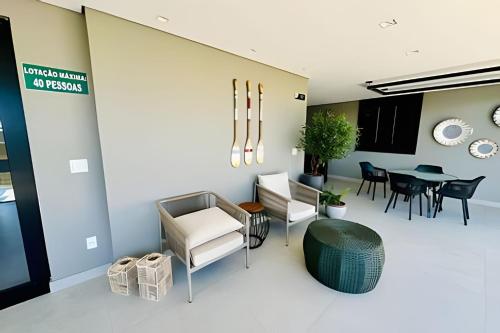 a living room with chairs and a table at Loft Skyline - Vista de tirar o fôlego para cidade! in Uberlândia