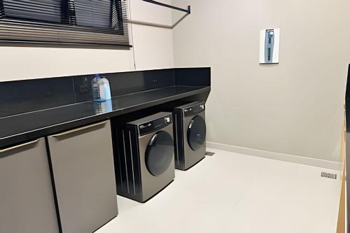 a laundry room with a washer and dryer at Loft Skyline - Vista de tirar o fôlego para cidade! in Uberlândia