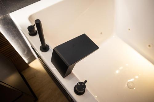 a white bath tub with a black box on it at Hotel Macami in El Carpio