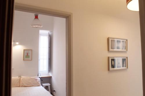 Schlafzimmer mit einem Bett, einem Fenster und einem Spiegel in der Unterkunft Casa da Catedral in Porto