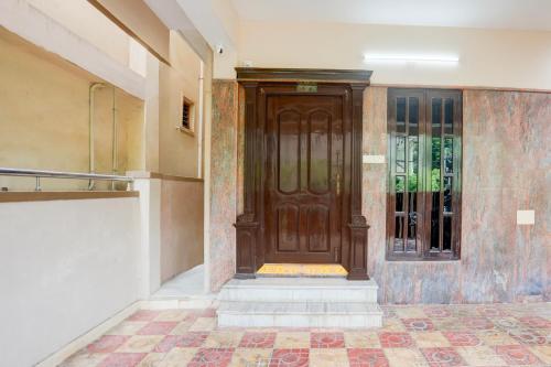 a wooden door in a building with a tile floor at Hotel O M.P GUEST INN in Nellore