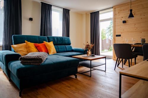 een woonkamer met een blauwe bank en een tafel bij Ferienapartments HarzZeit in Wernigerode