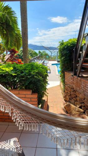 a hammock on a patio next to a swimming pool at Pousada Palmeiras Bombinhas in Bombinhas