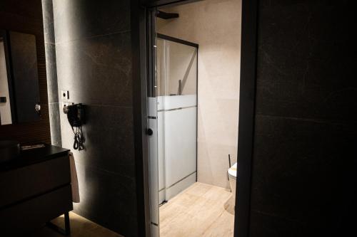 a bathroom with a white door and a toilet at Hotel Macami in El Carpio