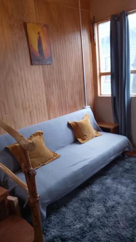 a bed with pillows on it in a room at Cabaña entre árboles in Neltume