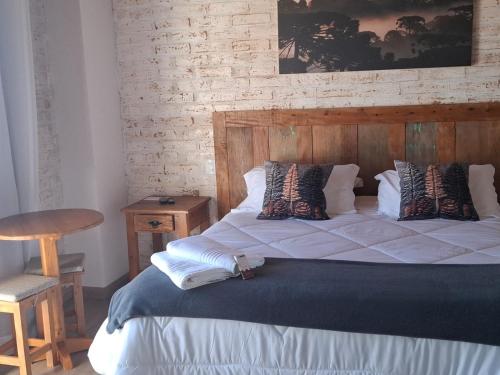 a bedroom with a large bed with a wooden headboard at Pousada Casa Pinha em Campos do Jordão in Campos do Jordão