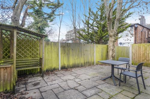 a patio with a table and chairs next to a fence at Central Harrow 5 Studio Apartment Block in Harrow
