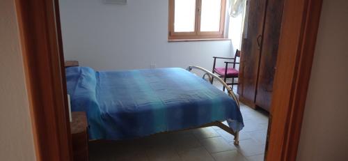 a room with a bed with a blue blanket on it at Agriturismo IL CERRO in Marzabotto