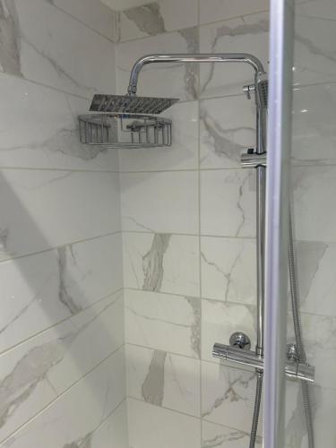 a shower with a glass door in a bathroom at Central Harrow 5 Studio Apartment Block in Harrow