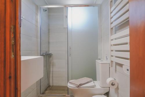 a white bathroom with a toilet and a shower at Sea house of Candia in Kandia