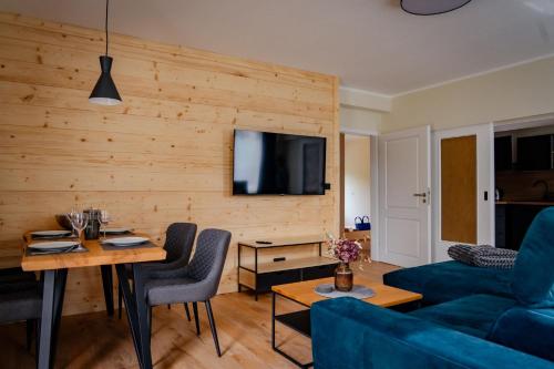 een woonkamer met een blauwe bank en een tafel bij Ferienapartments HarzZeit in Wernigerode