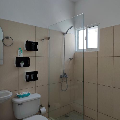 a bathroom with a shower and a toilet at Azure Breeze Hotel in Bayahibe
