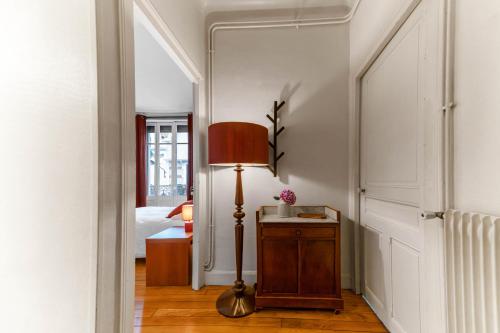 a hallway with a lamp and a bed at Appartement André Thérèse, calme Belle Epoque in Vichy