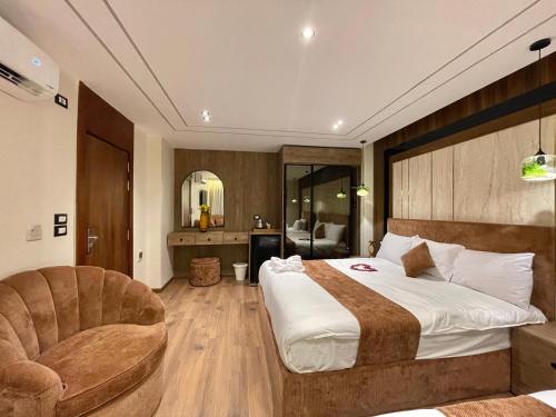 a bedroom with a large bed and a chair at City plaza pyramids view in Cairo