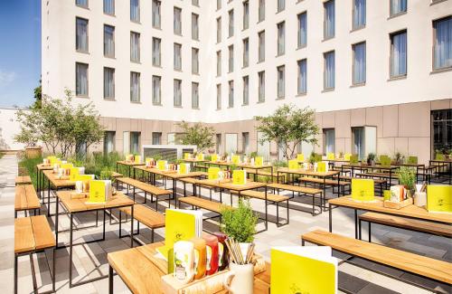 an outdoor patio with tables and chairs and a building at NYX Hotel Munich by Leonardo Hotels in Munich