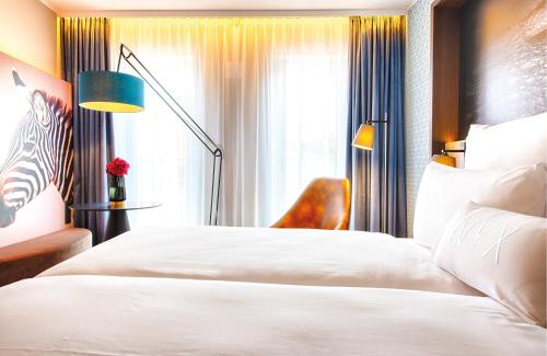 a hotel room with a bed and a window at NYX Hotel Munich by Leonardo Hotels in Munich