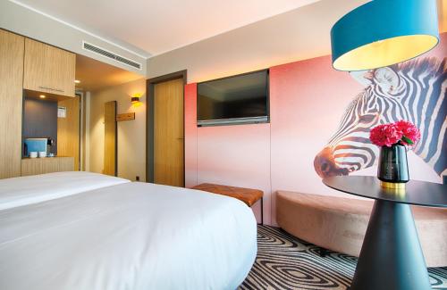a hotel room with a bed and a table with a zebra mural at NYX Hotel Munich by Leonardo Hotels in Munich