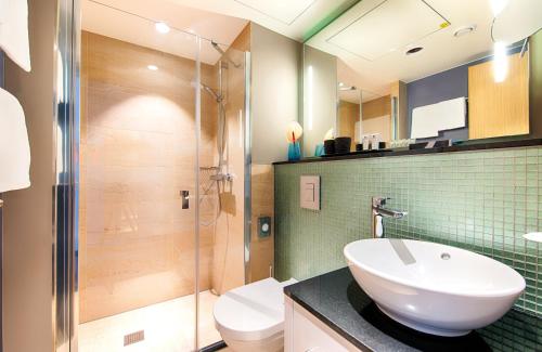 a bathroom with a toilet and a sink and a shower at NYX Hotel Munich by Leonardo Hotels in Munich