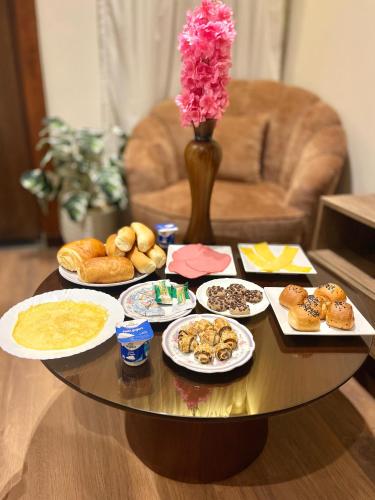a table with plates of donuts and a vase with flowers at City plaza pyramids view in Cairo