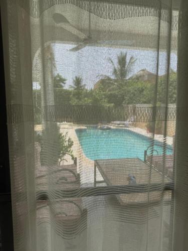 a window with a view of a swimming pool at Atelier Industriel in Mbour