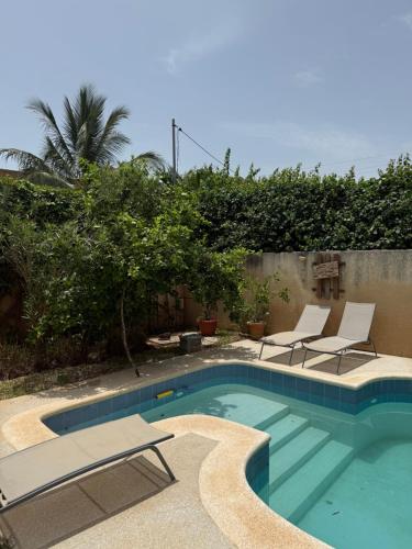a swimming pool with lounge chairs and a swimming pool at Atelier Industriel in Mbour