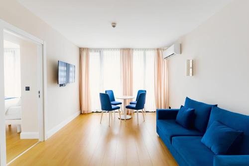 a living room with a blue couch and chairs at Panorama Sea Side Hotel in Batumi