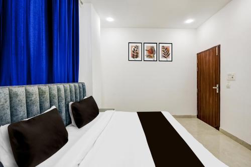 a bedroom with a bed with a blue curtain at Hotel O A-1 Stays in Faridabad