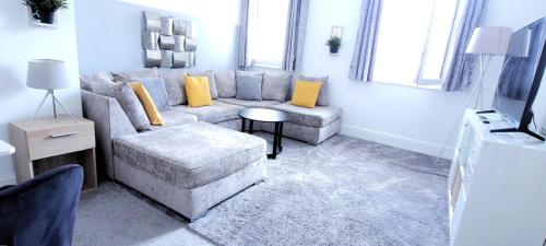 a living room with a couch and a chair at Wigan Central Executive Apartments I Family Rooms I Free Parking in Wigan
