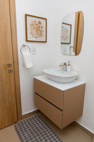 a bathroom with a sink and a mirror at Stylish Apartment with Modern Amenities in Nova Roman Ridge in Accra