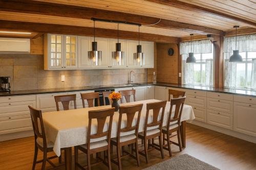 a kitchen with a table and chairs in a room at Family-friendly Cabin with pier - Herdla to Bergen - 40 min in Herlø