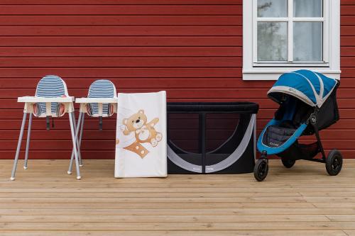 a baby stroller next to a table and two chairs at Family-friendly Cabin with pier - Herdla to Bergen - 40 min in Herlø