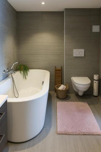 a bathroom with a white tub and a toilet at Family-friendly Cabin with pier - Herdla to Bergen - 40 min in Herlø