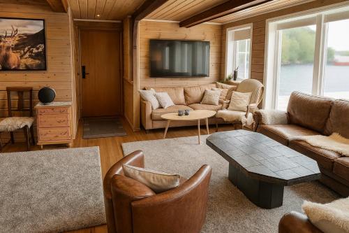 a living room with a couch and a tv at Family-friendly Cabin with pier - Herdla to Bergen - 40 min in Herlø