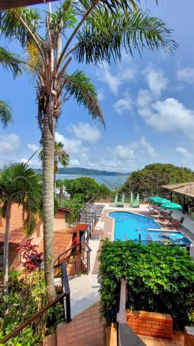 a resort with a pool and palm trees at Pousada Palmeiras Bombinhas in Bombinhas